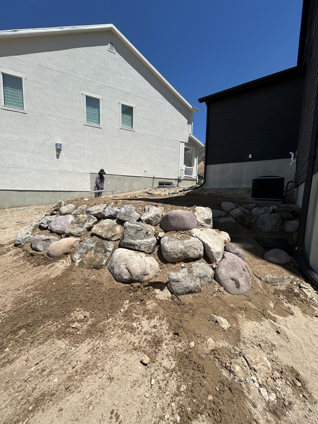 Boulder retaining wall set between two homes