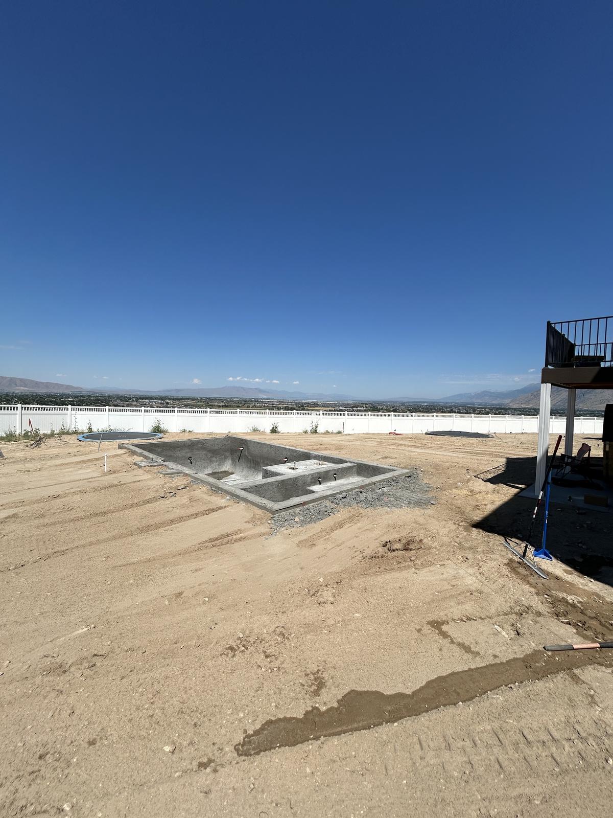 Graded backyard with a new pool shell and valley view